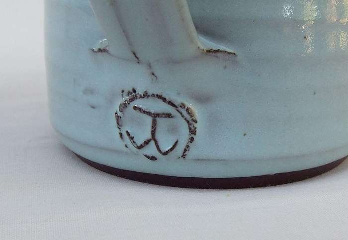 A signed South African pottery mug with frog motif