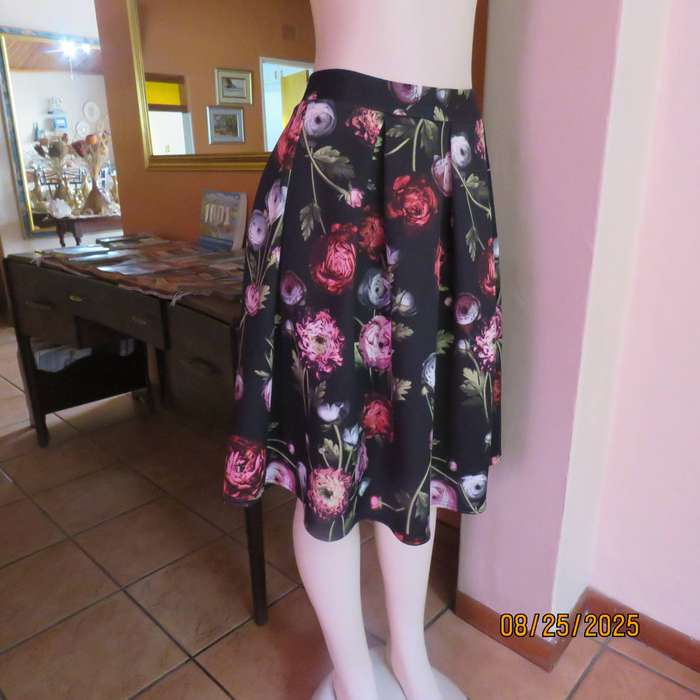 Black firm stretch polyester with red-pink floral print. With box pleats. Size 36