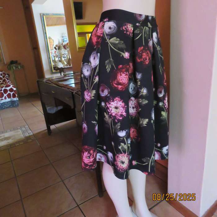 Black firm stretch polyester with red-pink floral print. With box pleats. Size 36