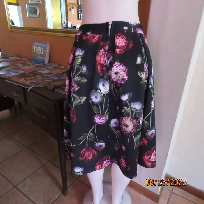 Black firm stretch polyester with red-pink floral print. With box pleats. Size 36