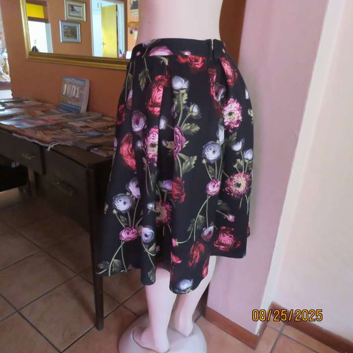 Black firm stretch polyester with red-pink floral print. With box pleats. Size 36