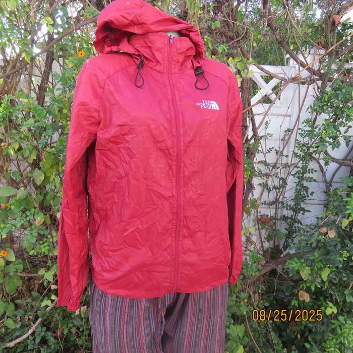 THE North Face red nylon windbreaker size 36 with hood and drawstrings.