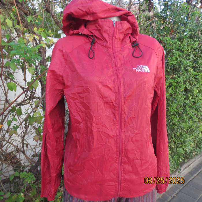 THE North Face red nylon windbreaker size 36 with hood and drawstrings.