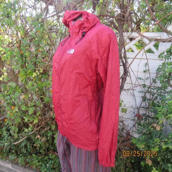 THE North Face red nylon windbreaker size 36 with hood and drawstrings.