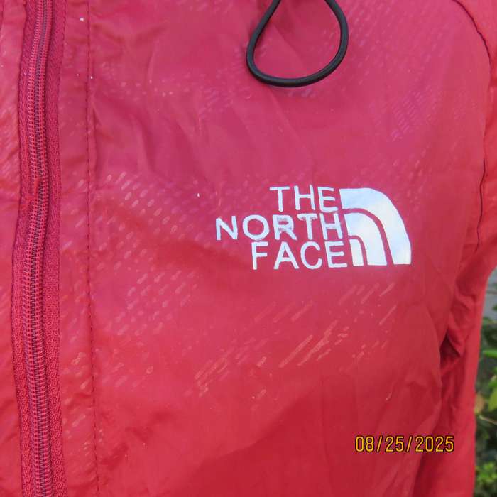 THE North Face red nylon windbreaker size 36 with hood and drawstrings.