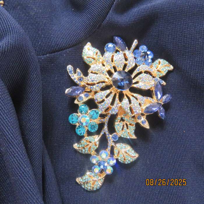 Blue stone on golden base very large brooch-decoration. 6 different stones. New