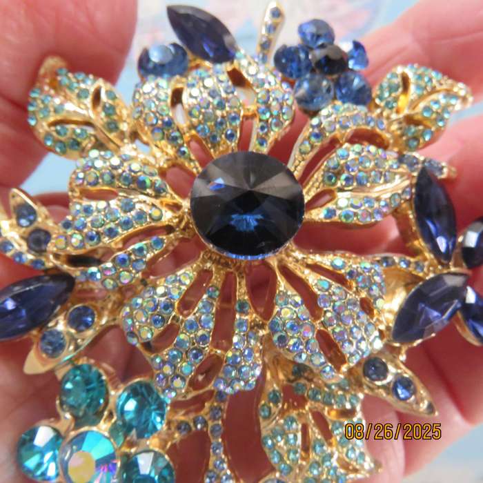 Blue stone on golden base very large brooch-decoration. 6 different stones. New