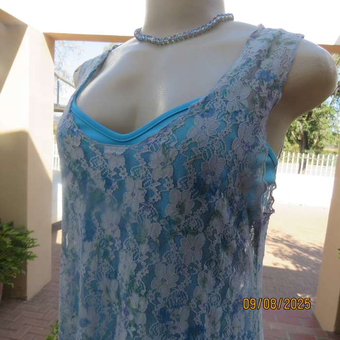 Light blue stretch acrylic lace high-low long top in floral pattern size 36.