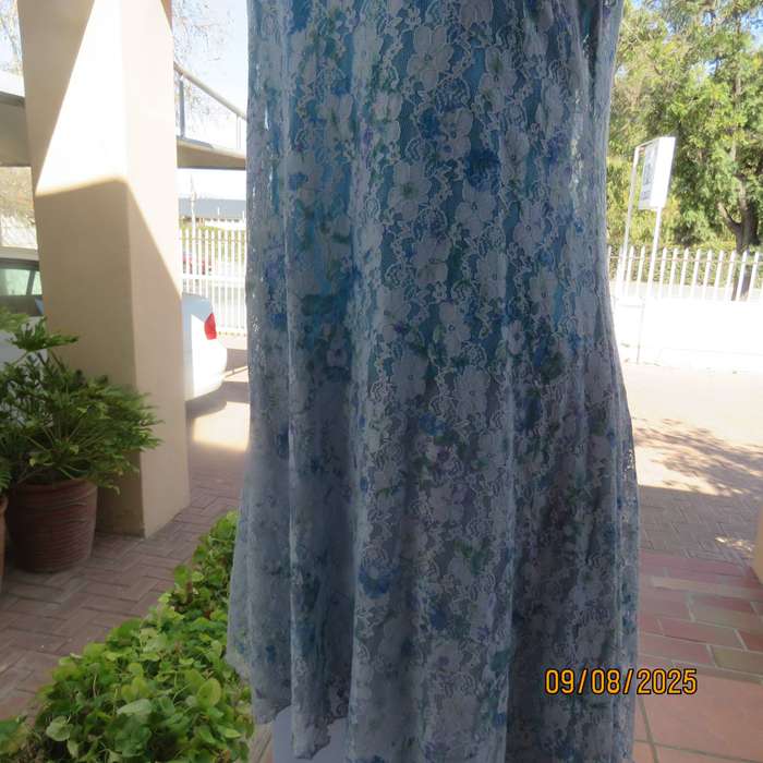 Light blue stretch acrylic lace high-low long top in floral pattern size 36.