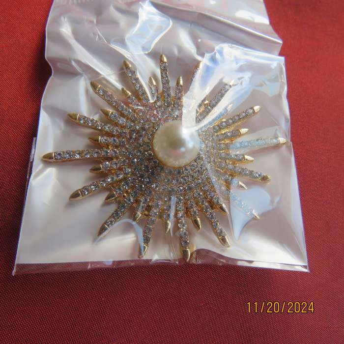 Unique shiny delicate brooch with lots of simulated diamonds on gold. Faux pearl in center.New item