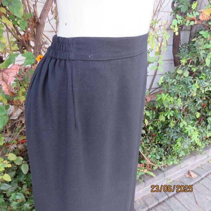 Very black lined ankle length polyester pencil skirt. Size 44 loose fit. Elasticated sides.