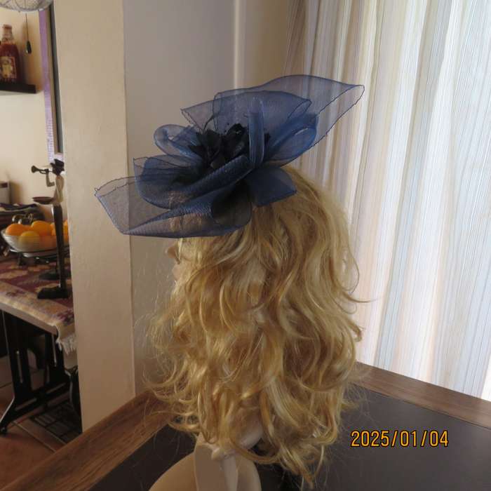 Make a statement wearing this navy double bow mesh fascinator with flower and feathers. New item