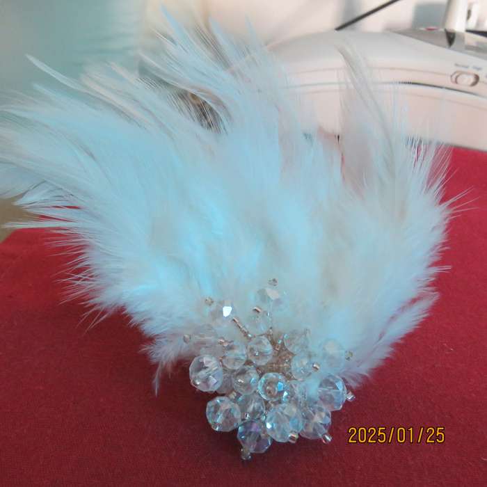 Chic romantic white feather brooch. Faux crystal flower center. Suitable for smart event. New item.