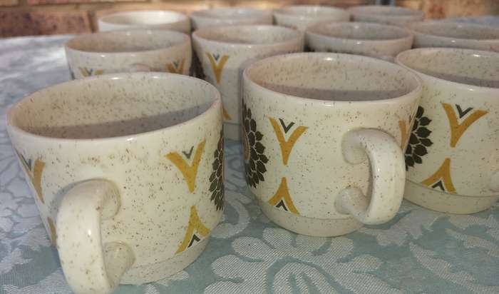 A VINTAGE STONEWARE SUNFLOWER DESIGN 24-PIECE TEACUP AND SAUCER SET