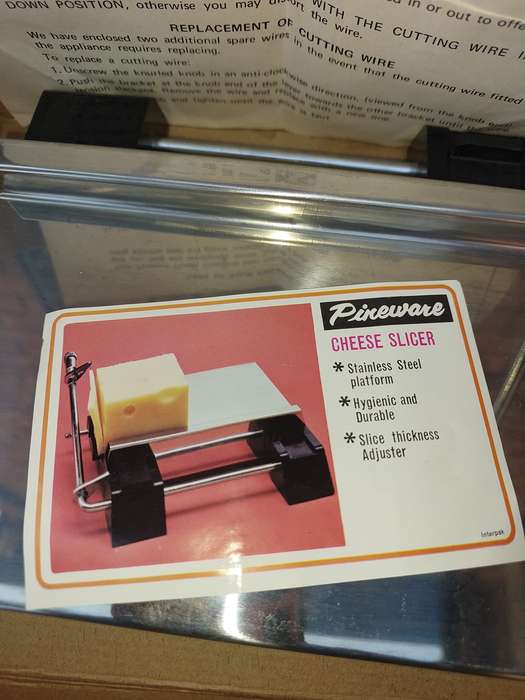 A VINTAGE PINE WARE CHEESE SLICER IN IT ORIGINAL PACKAGING