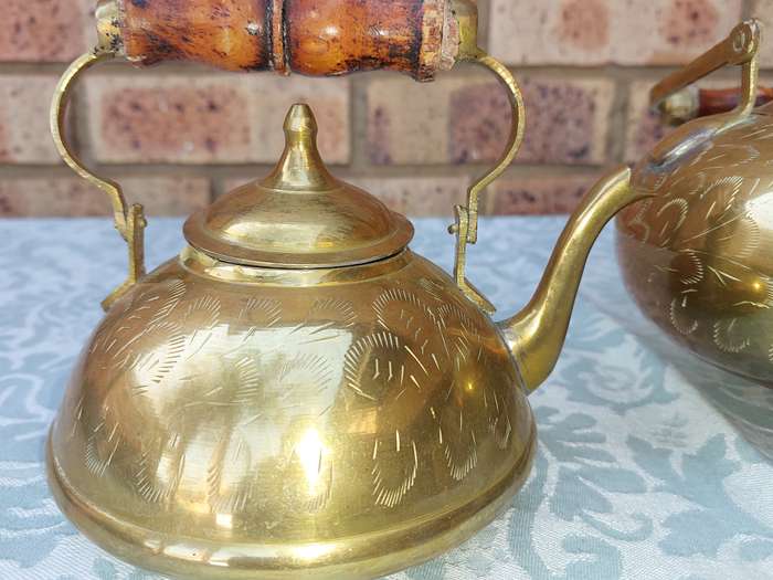 A SET OF BRASS ART DECOR KETTLES WITH AN ASIAN DESIGN