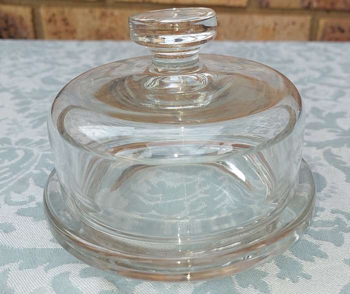 A SOLID GLASS BUTTER BOWL WITH A LID
