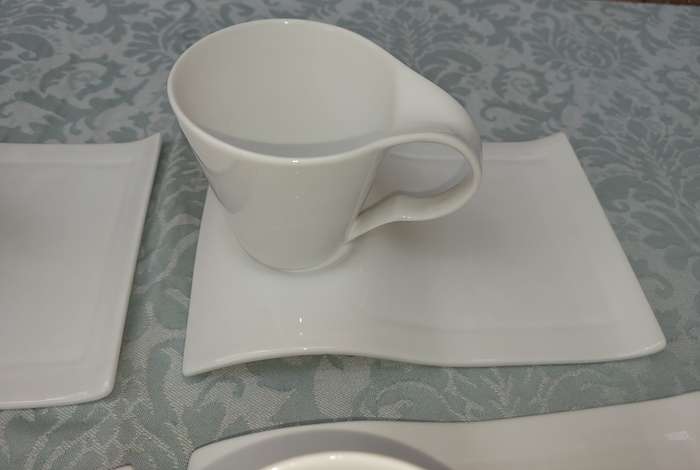 A SET OF 4 PURE WHITE FUNKY PORCELAIN CUPS AND SAUCERS