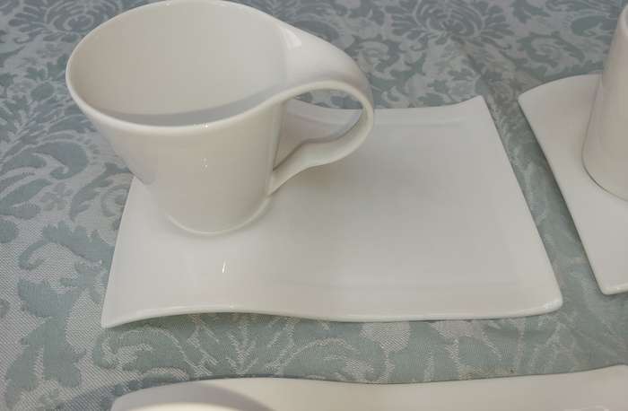 A SET OF 4 PURE WHITE FUNKY PORCELAIN CUPS AND SAUCERS