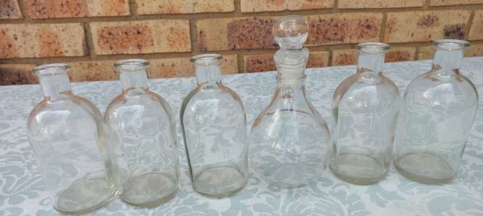 A COLLECTION OF GLASS SAUCE BOTTLES SOLD AS IS