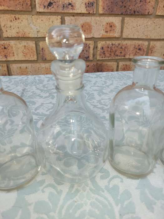 A COLLECTION OF GLASS SAUCE BOTTLES SOLD AS IS