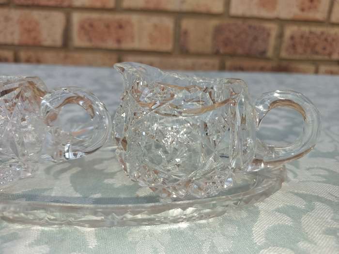 AN ART DECOR GLASS SUGAR BOWL AND A MILK JUG SOLD AS IS