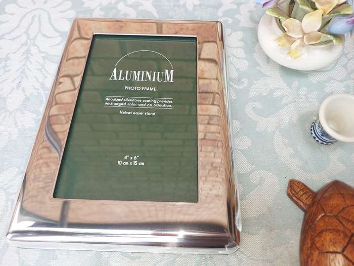 A COLLECTION OF FIGURINES AND A SILVER PLATED PHOTO FRAME SOLD AS IS