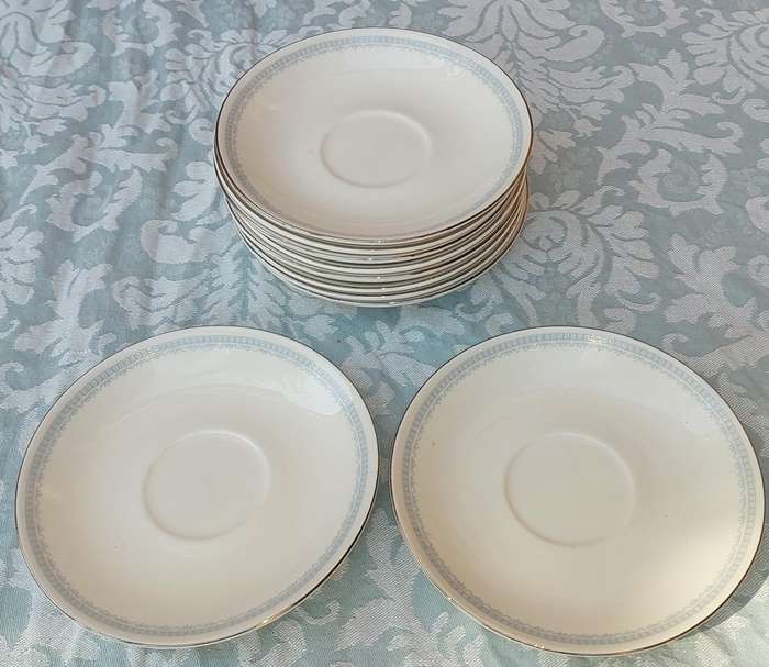 A COLLECTION OF 10 CONTINENTAL SAUCERS WHITE WITH SILVER TRIM AND LIGHT BLUE ART WORK SOLD AS IS