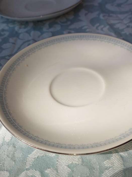 A COLLECTION OF 10 CONTINENTAL SAUCERS WHITE WITH SILVER TRIM AND LIGHT BLUE ART WORK SOLD AS IS