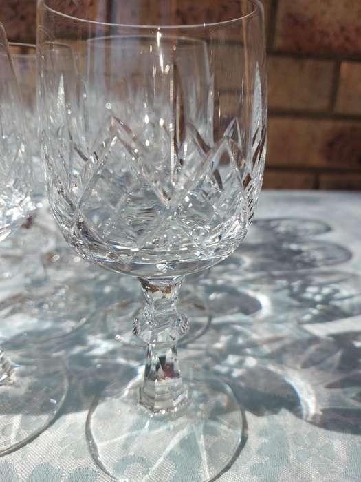 A SET OF 12 CRYSTAL WINE GLASSES WITH STEMS SOLD AS IS