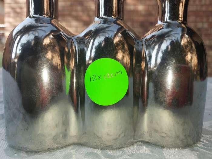A COLLECTION OF SILVER PLATED CAST BOTTLE VASES SOLD AS IS