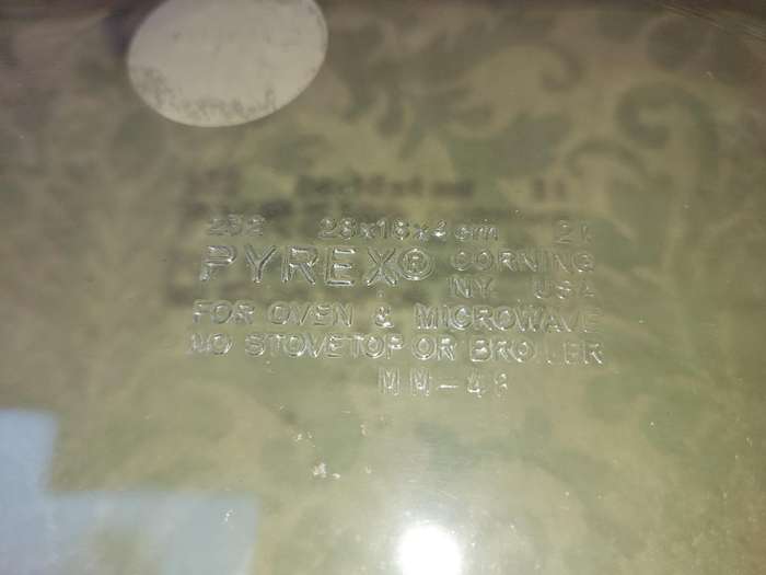A VIBTAGE B PYREX CORNING CASSEROLE AND A STAND SOLD AS IS