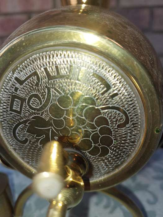 A VINTAGE HEBREW WINE DECANTER AND SIX CUPS BRASS ON A STAND ONE CUP NEED THE HANDLE TO BE ATTACHED