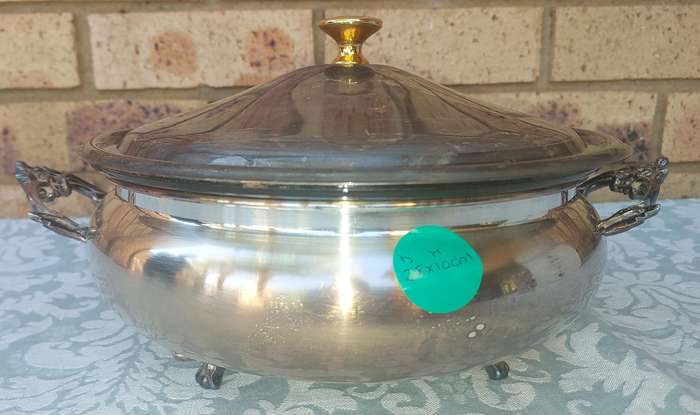 A VINTAGE SILVER TUREEN WITH A PYREX INNER GLASS COMPARTMENTED WITH A GOLD HANDLE LID