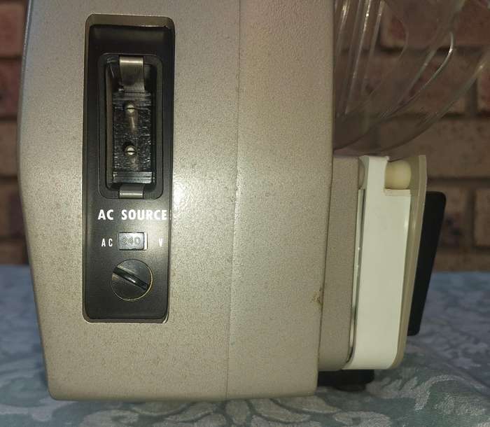 AN ANTIQUE MOVIE PROJECTOR WIYHOUT THE POWER CABLE SOLD AS IS NOT TESTED
