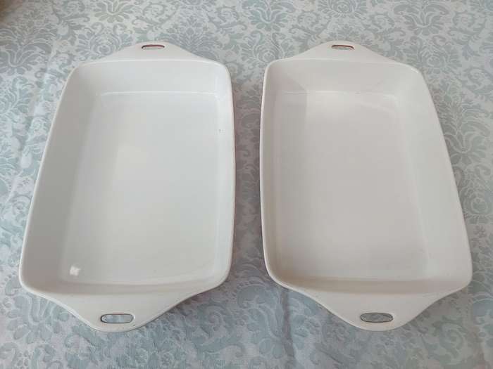 A PAIR OF RED AND WHITE CASSEROLE DISHES IN GOOD CONDITION SOLD AS IS