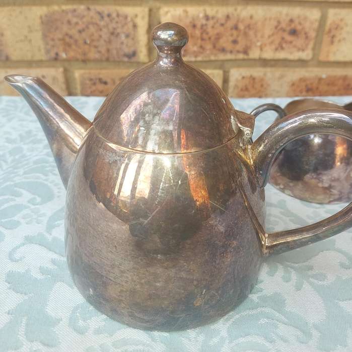 A VINTAGE SILVER PLATED TEAPOT WITH A MILK JUG AND A SUGAR BOWL SOLD AS IS