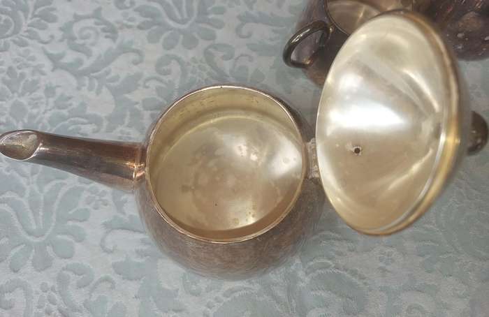 A VINTAGE SILVER PLATED TEAPOT WITH A MILK JUG AND A SUGAR BOWL SOLD AS IS