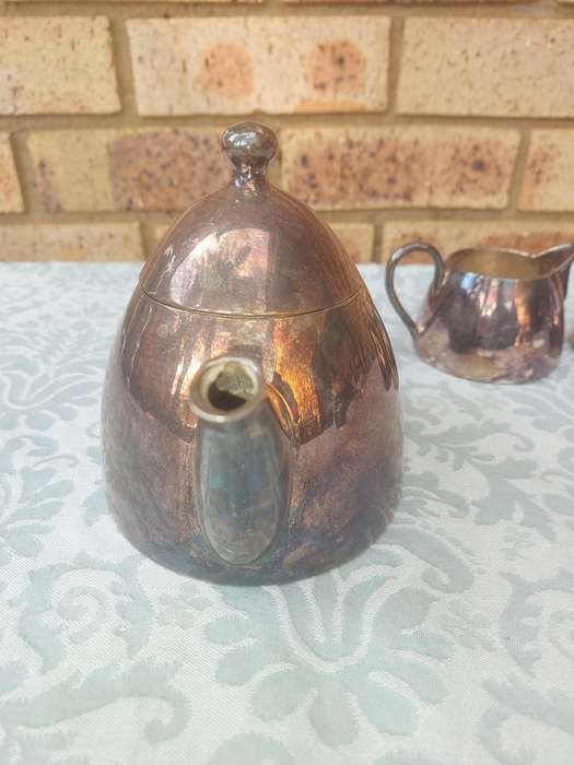 A VINTAGE SILVER PLATED TEAPOT WITH A MILK JUG AND A SUGAR BOWL SOLD AS IS