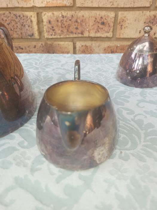 A VINTAGE SILVER PLATED TEAPOT WITH A MILK JUG AND A SUGAR BOWL SOLD AS IS