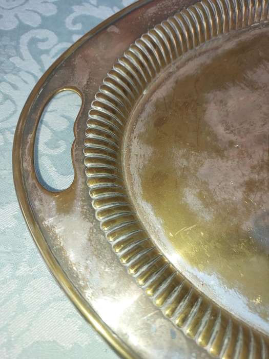 AN OVAL VICTORIAN SILVERPLATED ON BRASS TRAY SOLD AS IS