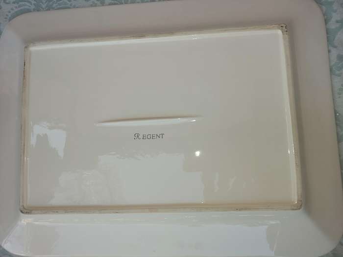 A COLLECTION OF WHITE PORCELAIN PLATTERS SOLD AS IS