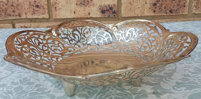 A VINTAGE SILVER PLATED BREAD BASKET SOLD AS IS