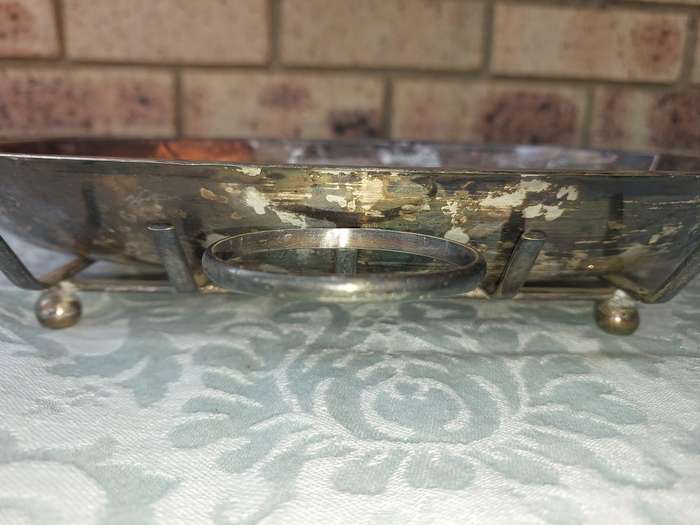 A VINTAGE SILVER PLATED SERVING PLATTER ON A SERVING STAND SOLD AS IS