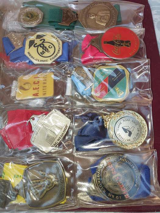 AN ENTIRE ATHLETES ALBUM WITH ALL THE MEDALS SOLD AS IS