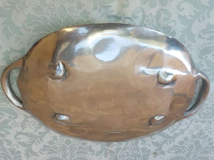 AN OVAL PEWTAL SERVING PLATTER SOLD AS IS
