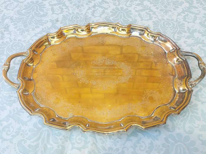 AN ANTIQUE 53 CENTIMETER SILVER PLATED ON BRONZE SERVING TRAY WIYH ENGRAVINGS SOLD AS IS