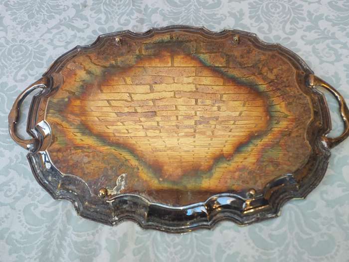AN ANTIQUE 53 CENTIMETER SILVER PLATED ON BRONZE SERVING TRAY WIYH ENGRAVINGS SOLD AS IS