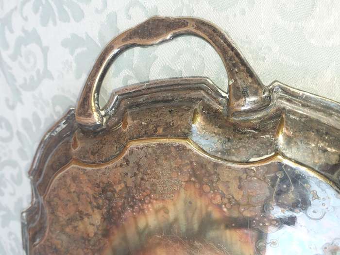 AN ANTIQUE 53 CENTIMETER SILVER PLATED ON BRONZE SERVING TRAY WIYH ENGRAVINGS SOLD AS IS