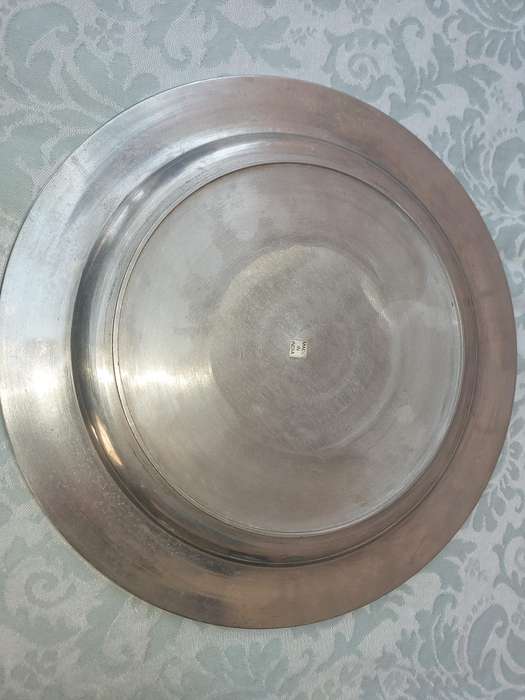 A ROUND PEWTAL SERVING TRAY  SOLD AS IS